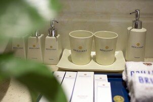 A bathroom with toiletries and a handwash dispenser.