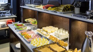 Een buffet met diverse gerechten, zoals fruit, kazen en gebak.