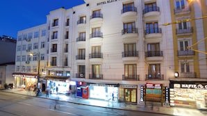Un hôtel à plusieurs étages doté de balcons, d’un bureau de change et d’un restaurant.