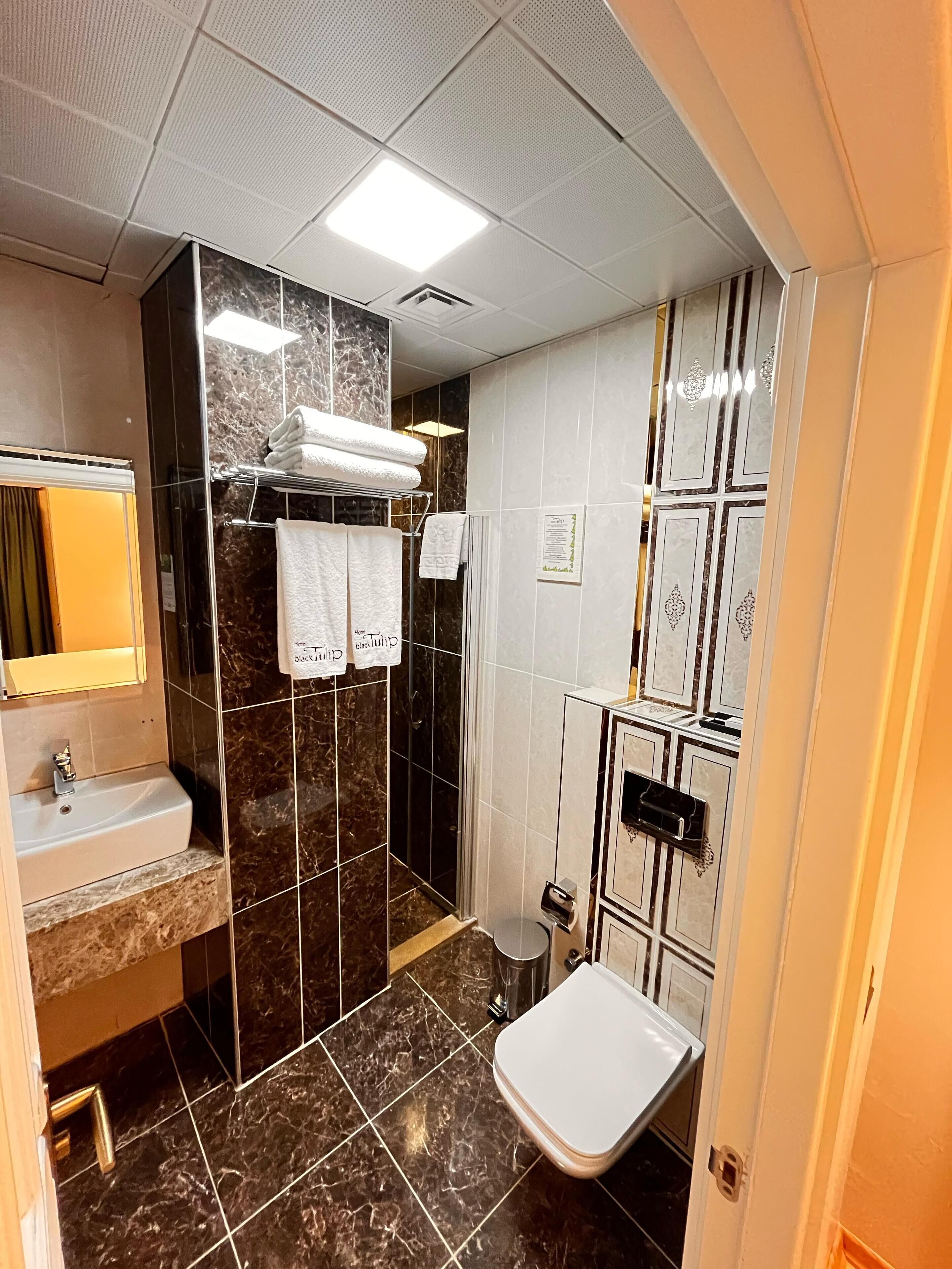 shower, hair dryer, slippers, towels