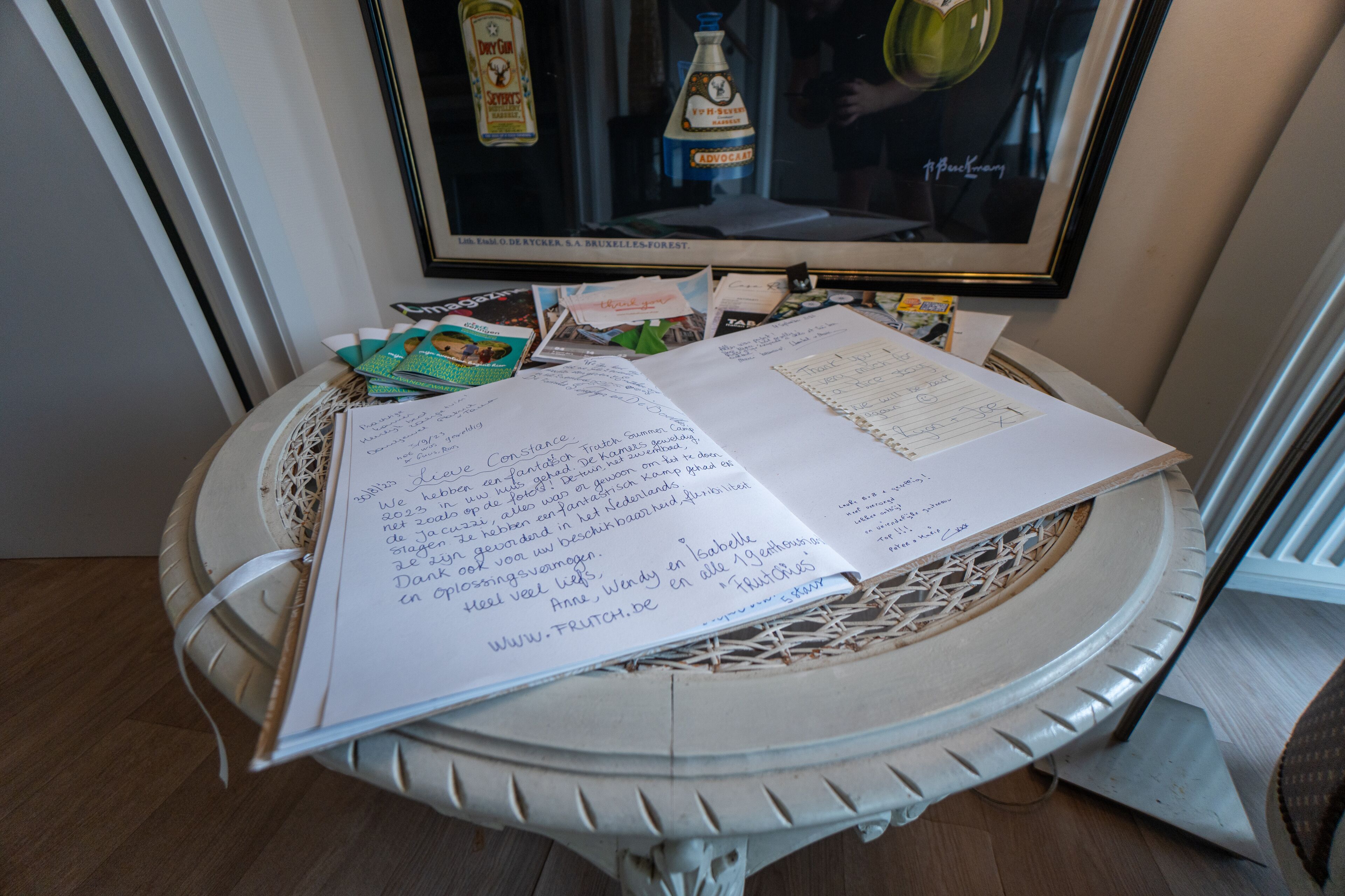 Een tafel met een notitieboek, papieren en een lijst met foto.