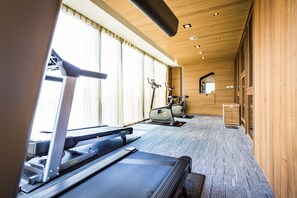A gym with exercise equipment, large windows, and wooden walls. - In Sky Hotel (Taichung)