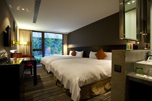A hotel room with two beds, a desk, a chair, a lamp, a mirror, and a window with a view of greenery. - In Sky Hotel (Taichung)