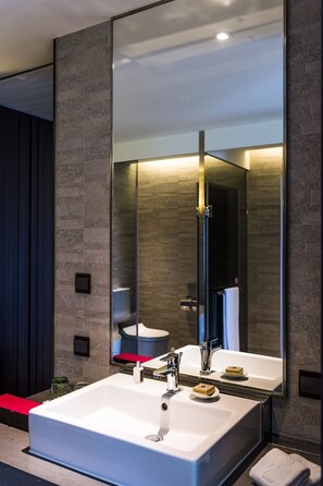 A modern bathroom with a large mirror, a white sink, and a red towel. - In Sky Hotel (Taichung)