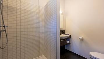 Un baño con ducha, lavamanos e inodoro.