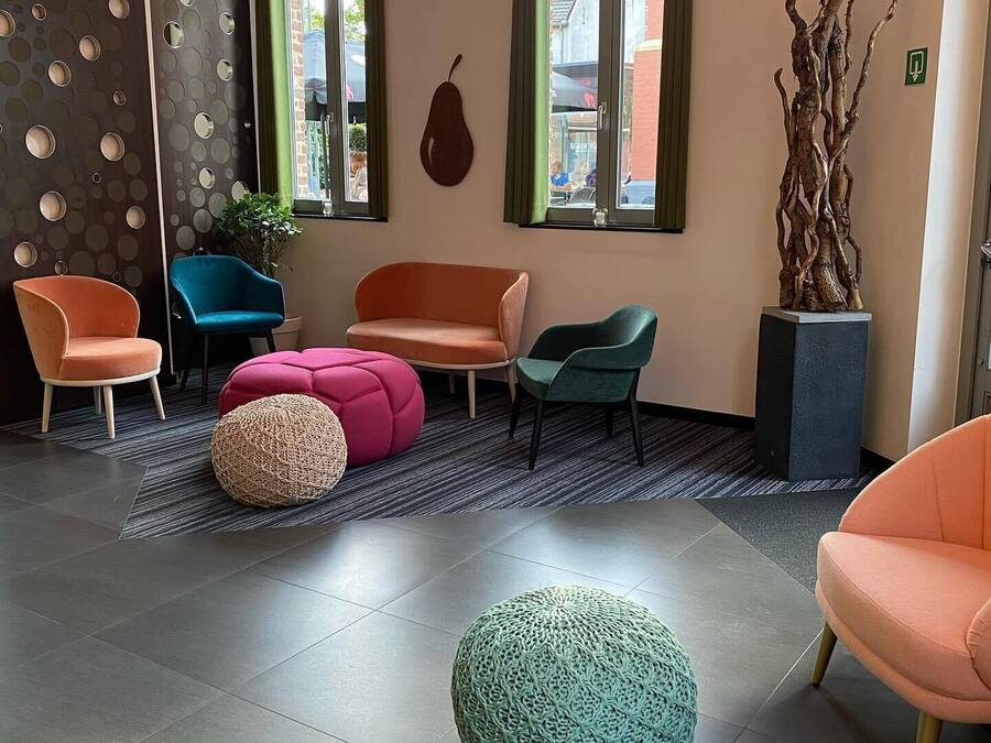 A modern interior with a seating area featuring multiple chairs and a large round ottoman.