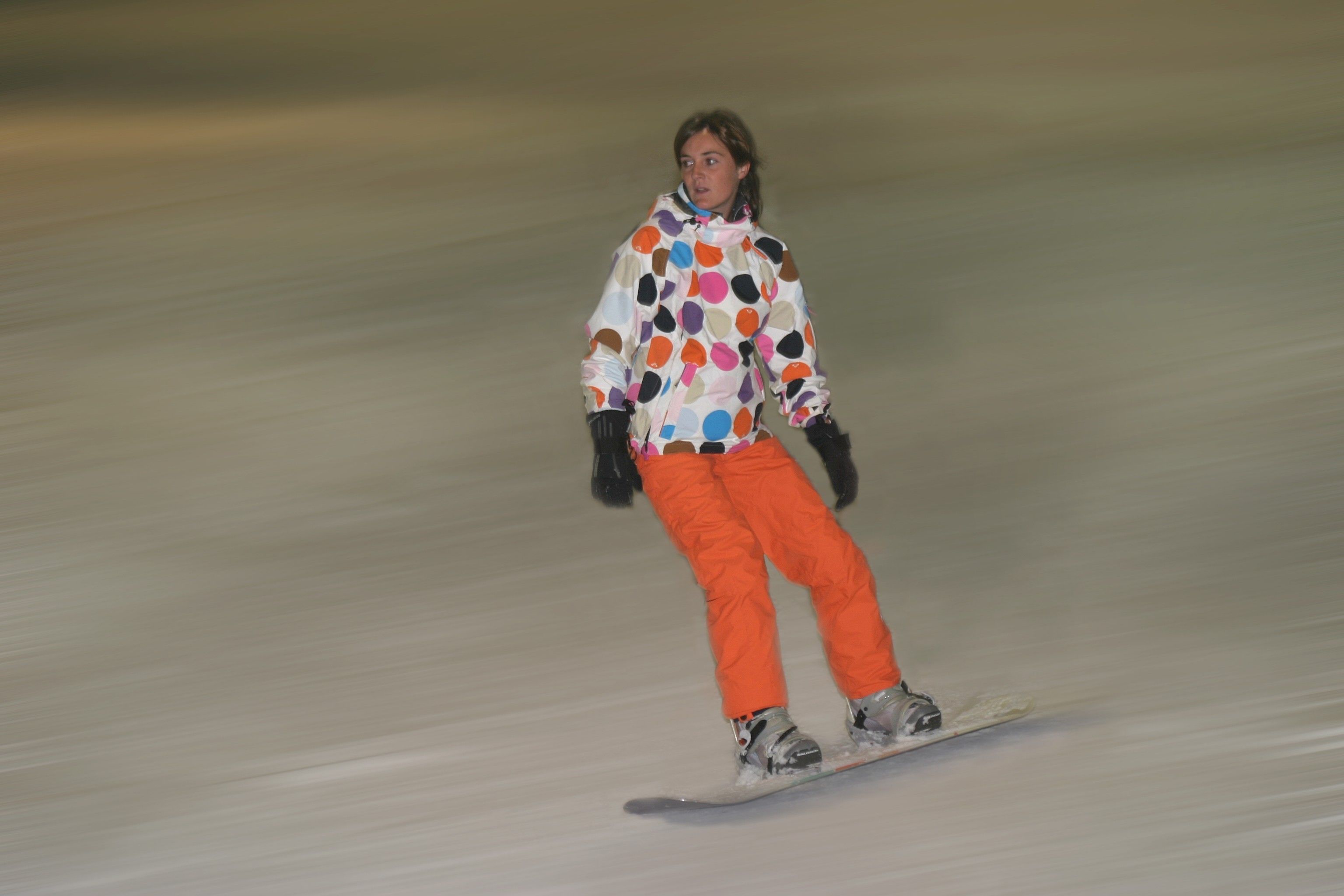 Una persona practicando snowboard en una ladera.