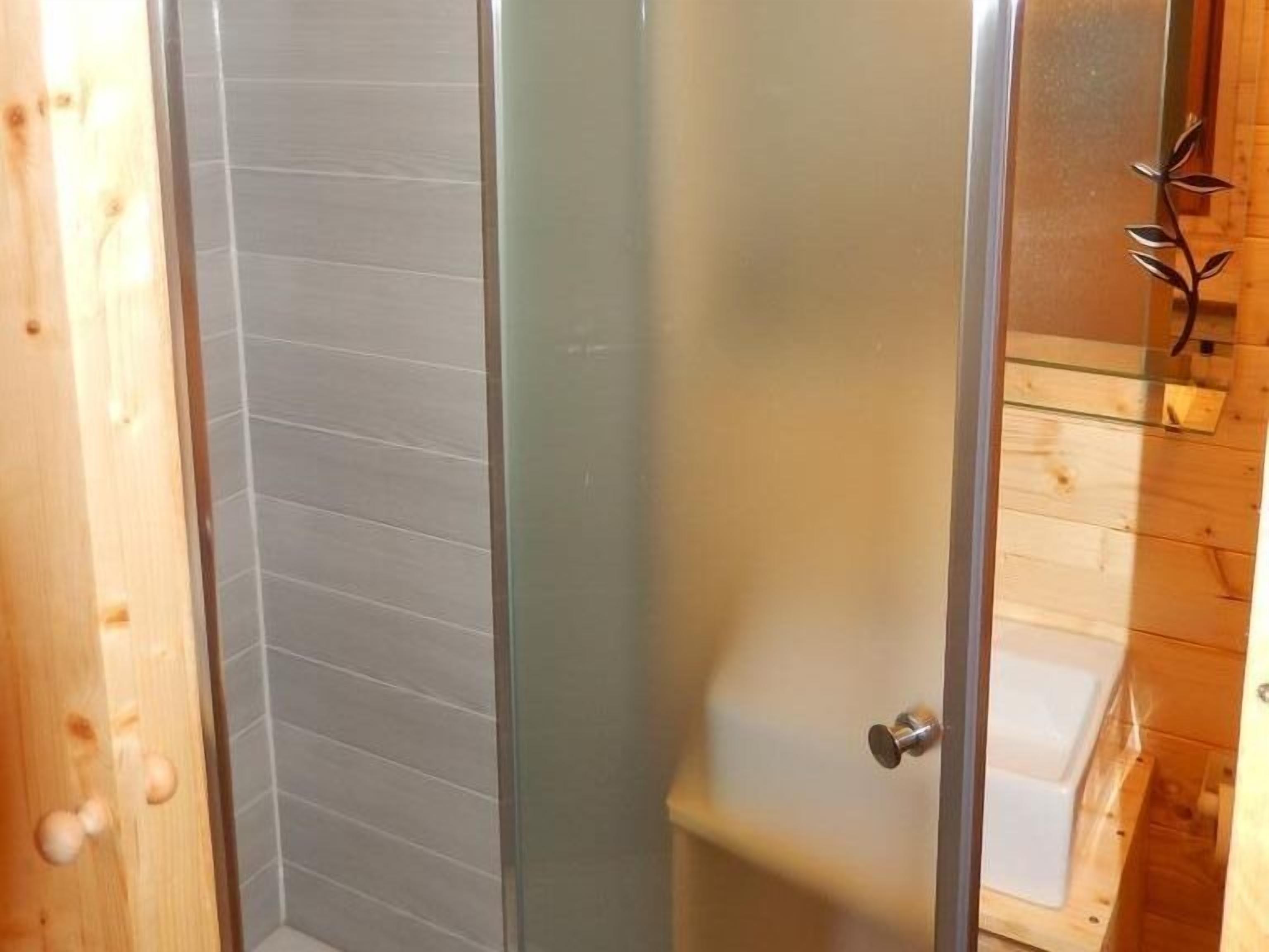 A wooden interior with a glass door leading to a shower area.
