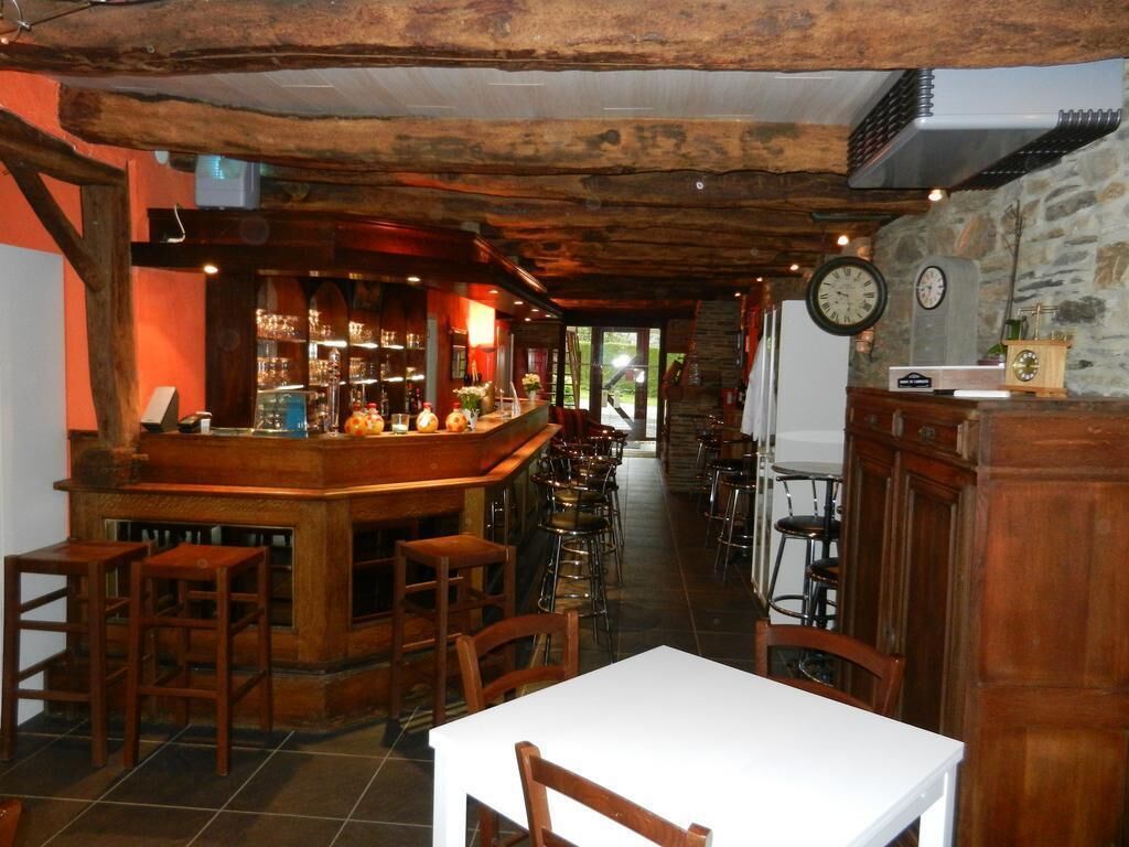 A rustic bar area with wooden furniture and a stone wall.