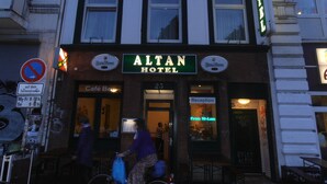 The exterior of the Altan Hotel with a sign indicating a café bar inside. - ALTAN Hotel (Hamburg)