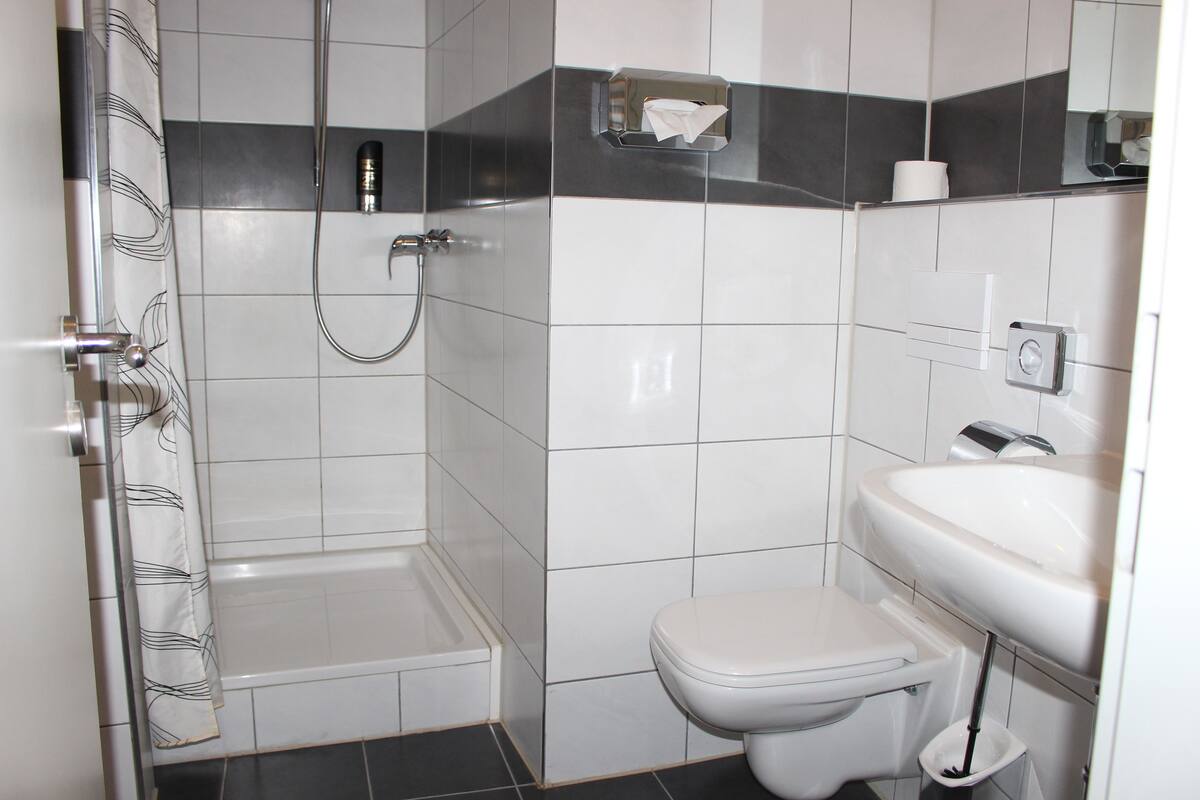 Un bagno moderno con doccia, toilette e lavandino.