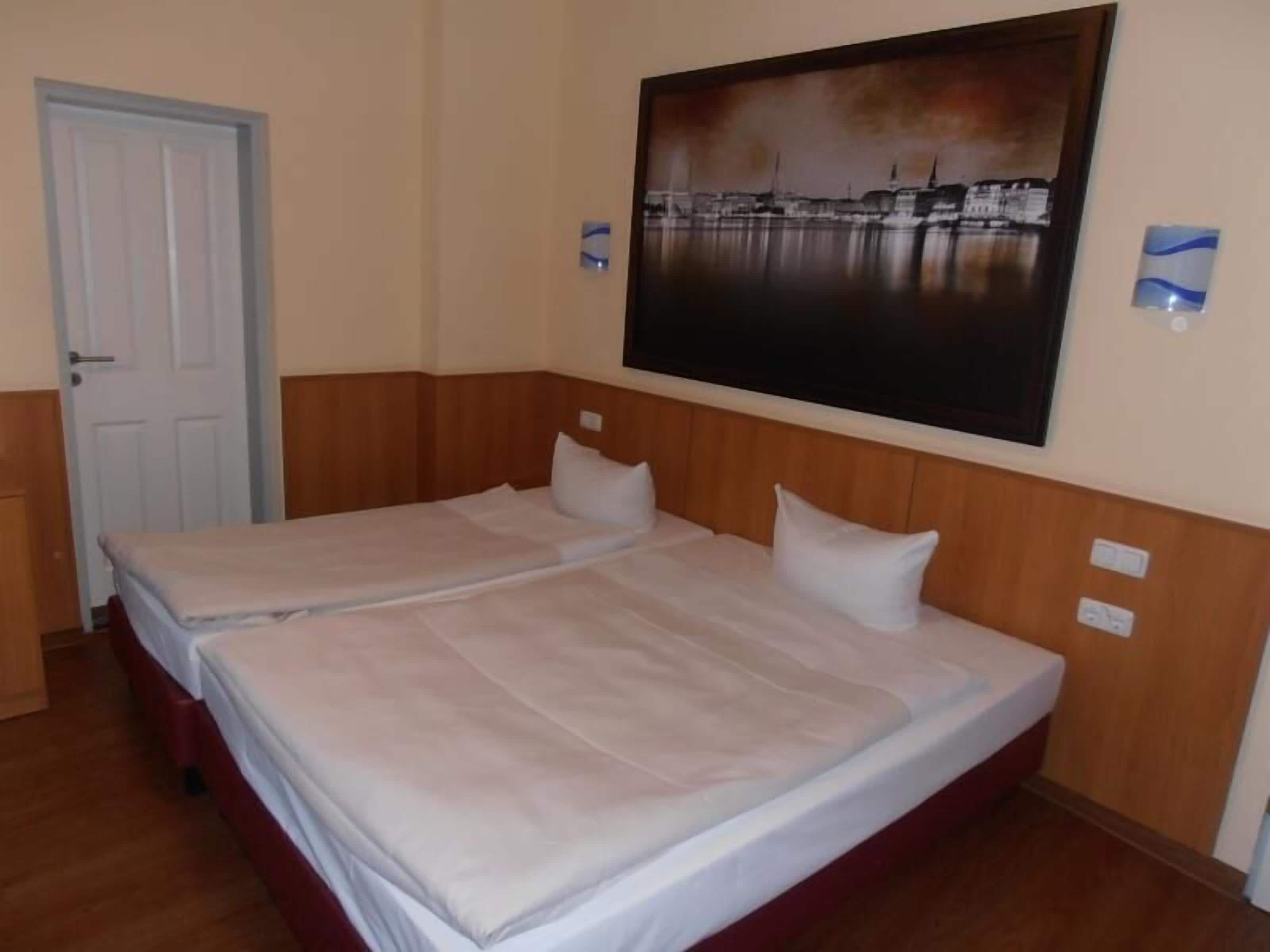 A double bed with a wooden headboard in a hotel room.