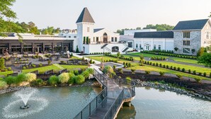 A lakeside hotel with a central courtyard, a bridge over the water, and a tower structure. - Chateau Renault (Egg Harbor City)