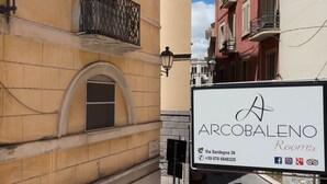 A building with a sign for 'Arcobaleno Rooms' at Via Sardegna 38. - Arcobaleno Rooms (Cagliari)