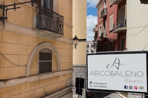Un edificio con un cartello che indica 'Arcobaleno Rooms' in Via Sardegna 38.