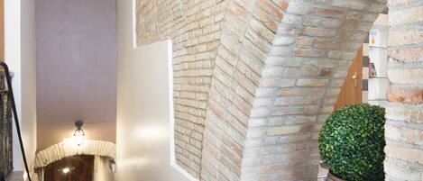 A staircase with a brick wall and a wooden door at the bottom.