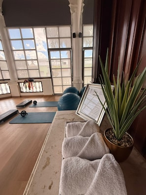 A room with exercise mats, a yoga wheel, a potted plant, and a framed certificate on a table. - Hotel Residencial (Mérida)