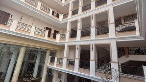 A multi-story residential building with balconies, a swimming pool, and a covered outdoor seating area. - Hotel Residencial (Mérida)