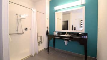 A bathroom with a shower, a sink, and a mirror.