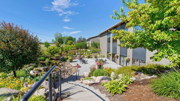 A modern building with a patio area, outdoor seating, and a stone staircase leading to the entrance. - Best Western Pembroke Inn & Conference Centre (Pembroke)