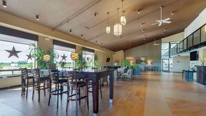A spacious indoor area with a long dining table and chairs, large windows, ceiling fans, and potted plants. - Best Western Pembroke Inn & Conference Centre (Pembroke)