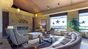A modern hotel lobby with a stone accent wall, comfortable seating, a large window with a city view, and decorative star-shaped lights. - Best Western Pembroke Inn & Conference Centre (Pembroke)
