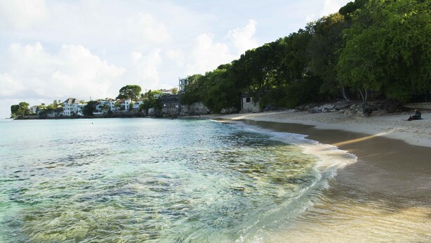 A beach with clear water, a sandy shore, and buildings in the background. - Best E Villas Prospect (Prospect)