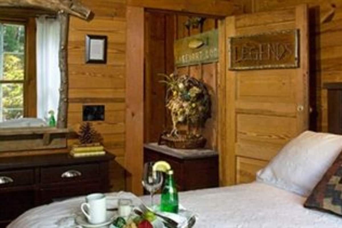 A wooden room with a bed, a dresser, a window, and a sign that reads "LEGIOS".