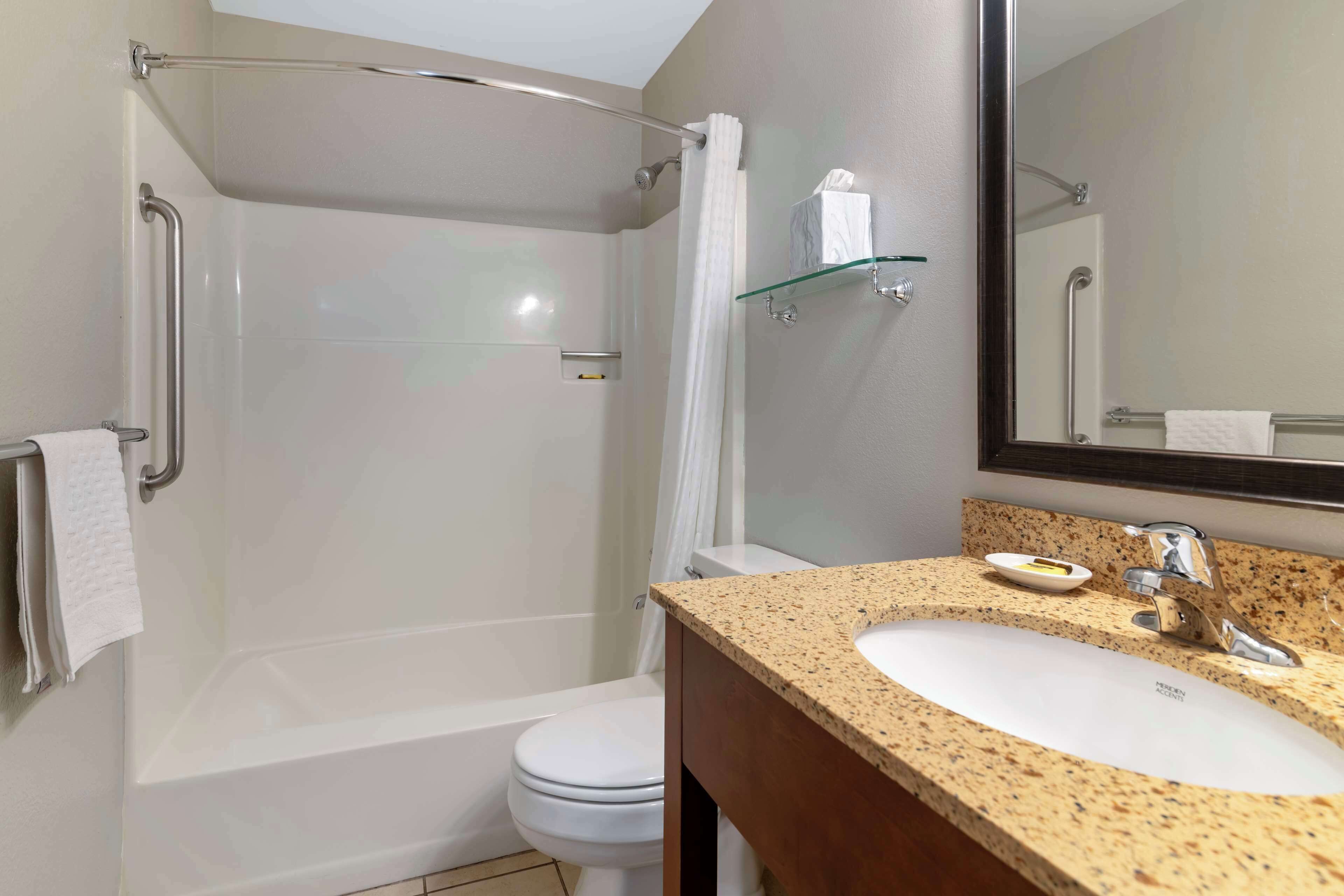 A modern bathroom with a bathtub, toilet, and sink.