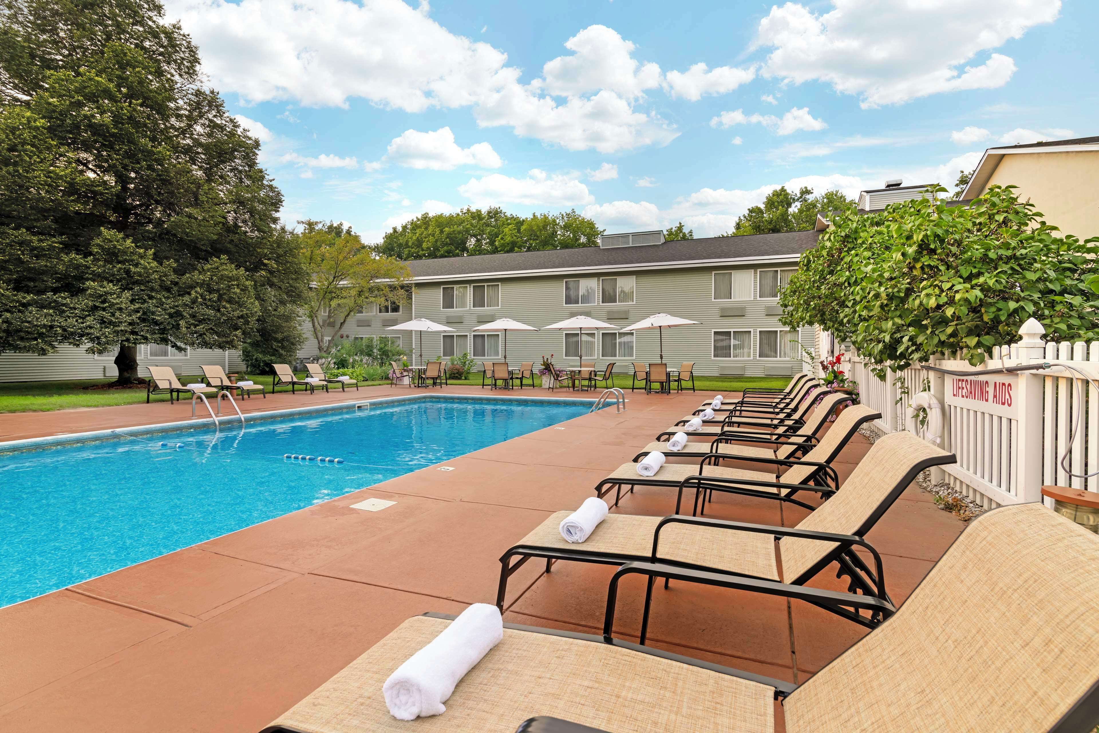 Alberca techada, alberca al aire libre y sombrillas en la alberca