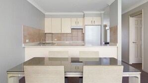 Una cocina compacta con una isla central, un refrigerador y armarios.