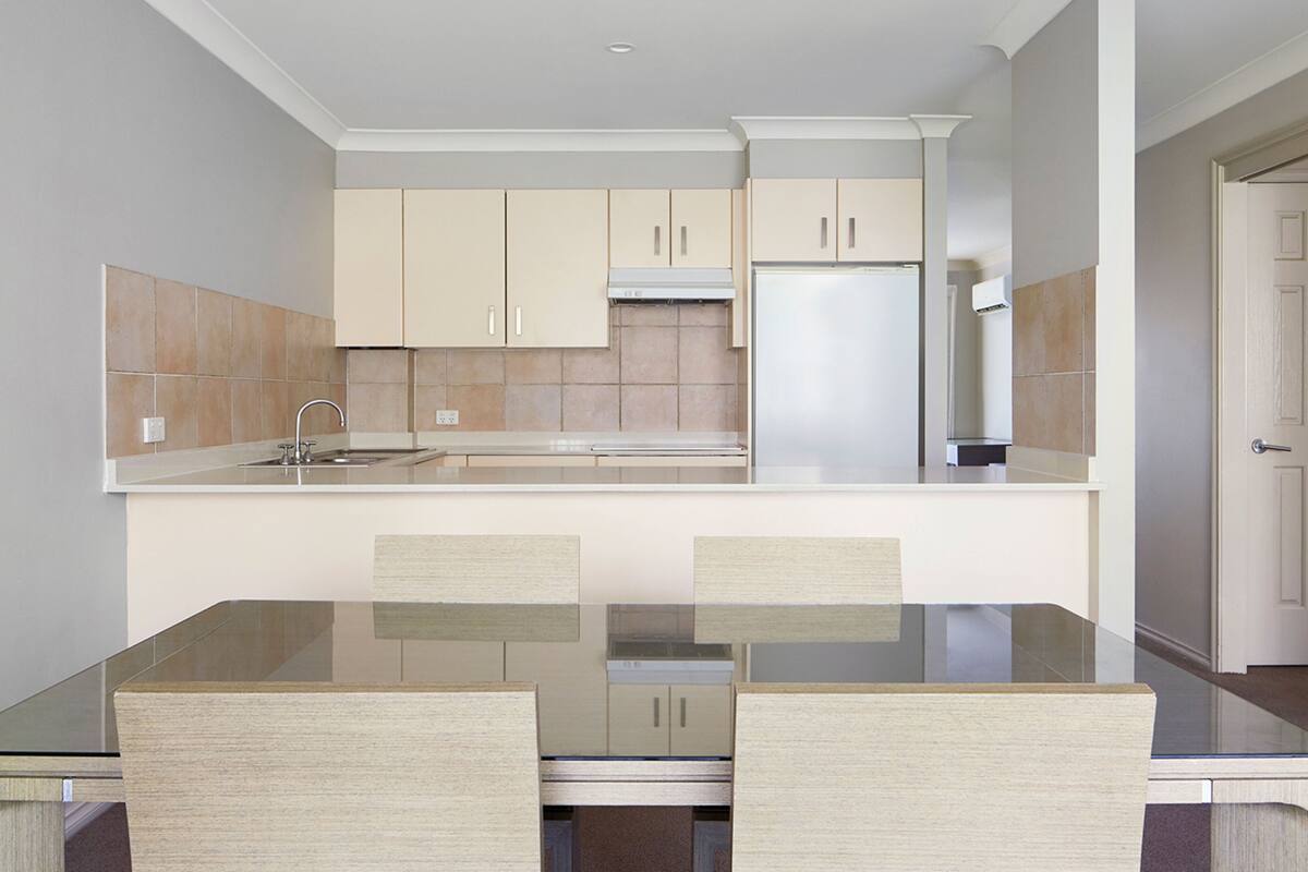 Una cocina compacta con una isla central, un refrigerador y armarios.