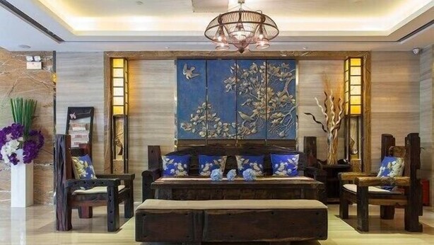 A lobby with a central seating area, a large wall mural, and a chandelier. - Wellgold Hotel (Guangzhou)