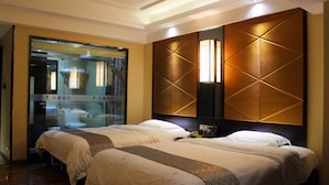 A hotel room with two beds, a glass partition, and a wall-mounted light fixture. - Wellgold Hotel (Guangzhou)