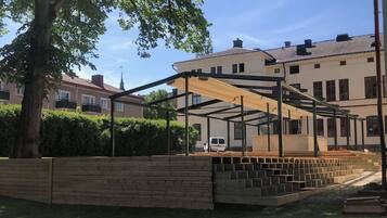 A courtyard with a wooden fence, a tree, and a building with multiple windows and balconies.