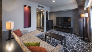 Uma sala de estar moderna com um sofá, uma mesa de centro, uma televisão e um tapete estampado.