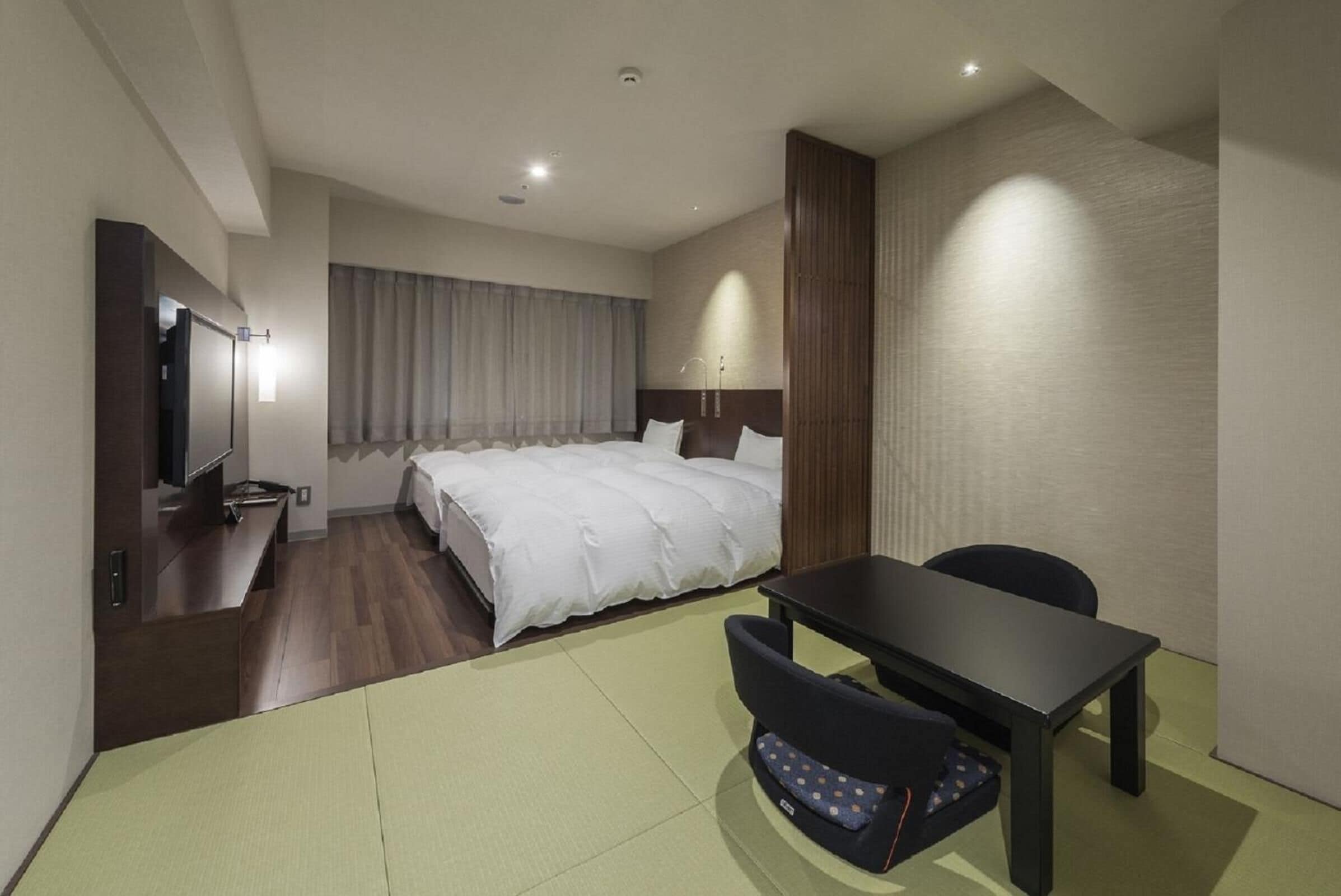 Ein modernes Hotelzimmer mit einem großen Bett, einem Schreibtisch und einem Sessel.