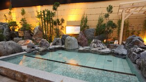 A pool with rocks and plants, surrounded by a tiled area. - -SPA RESORT- Nagoya Kasadera Hotel (Nagoya)