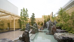 A tranquil indoor garden with a rock pond, wooden pergola, and bamboo plants. - -SPA RESORT- Nagoya Kasadera Hotel (Nagoya)