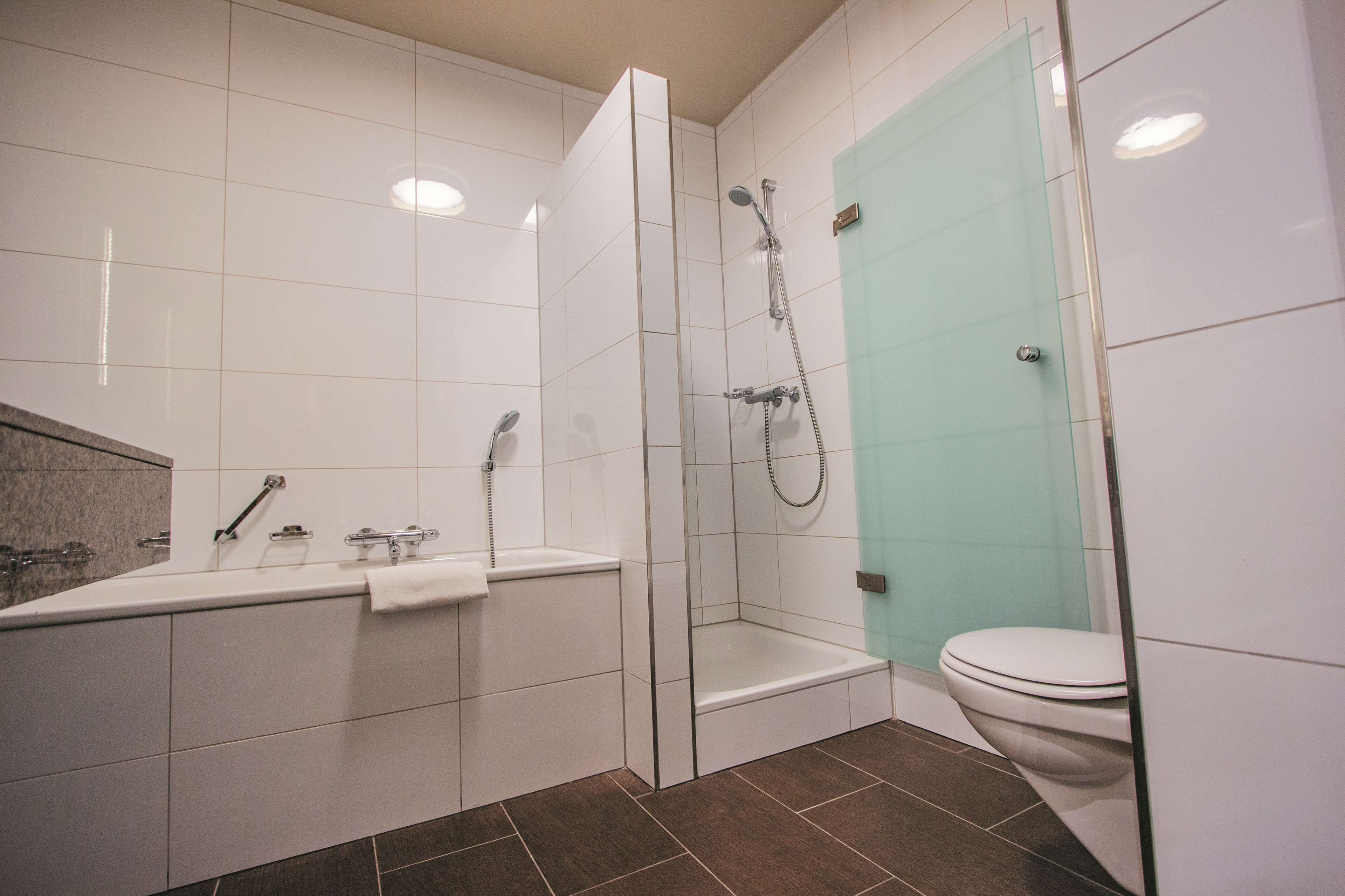 Un baño moderno con bañera, ducha e inodoro.