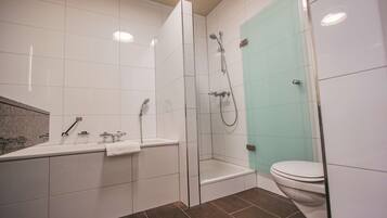Un baño moderno con bañera, ducha e inodoro.