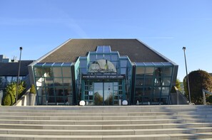 A modern hotel entrance with a glass facade and a sign reading "hotelmosis".