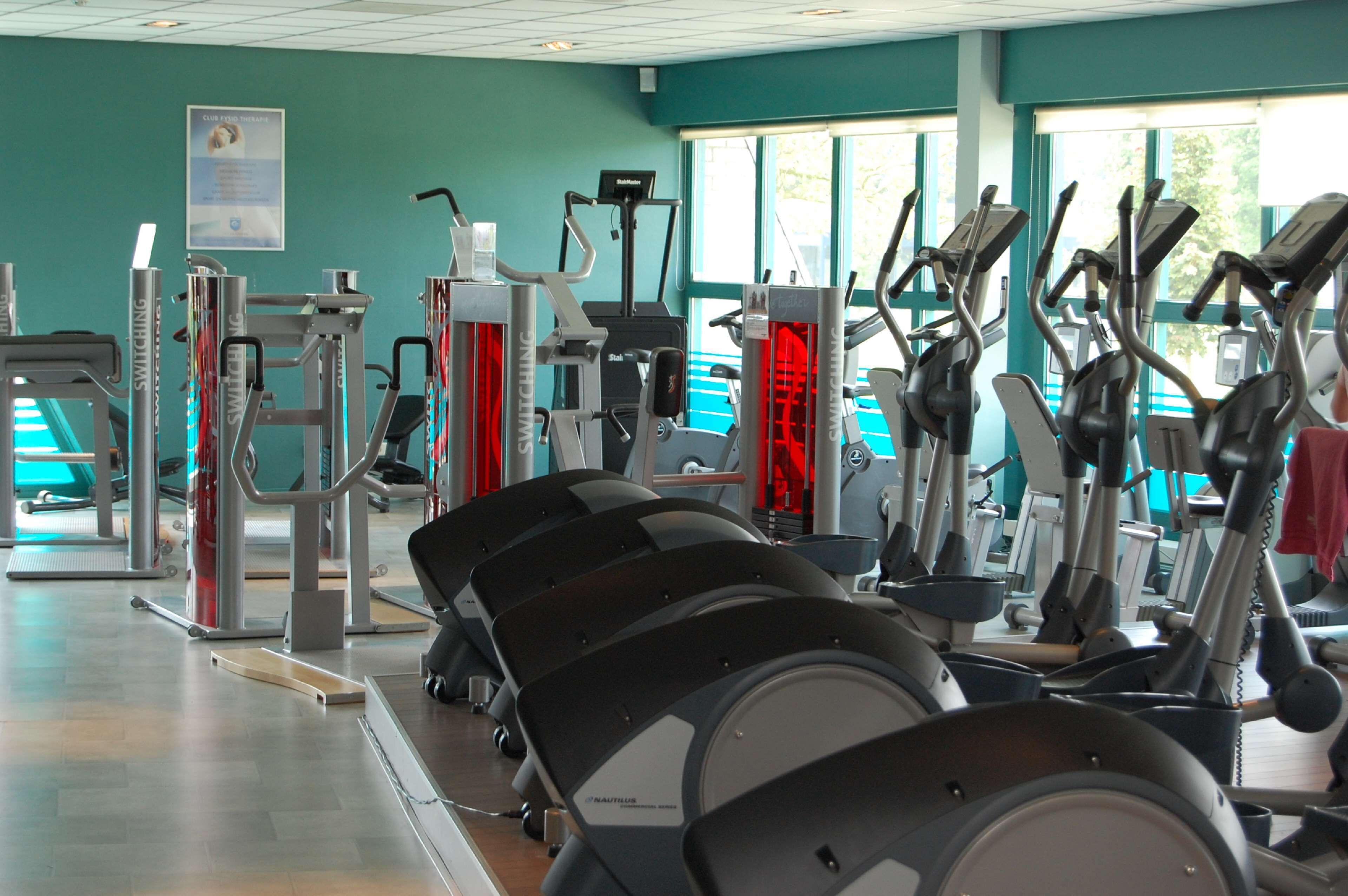 A gym with various exercise equipment including treadmills and weight machines.