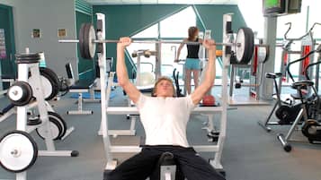 A gym with various exercise equipment, including a bench press and weight machines.