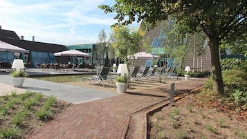 A courtyard with outdoor seating, potted plants, and a brick pathway.