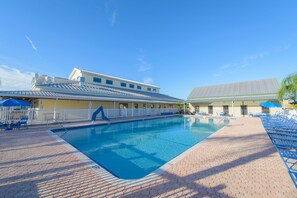 A swimming pool with a tiled deck, lounge chairs, and umbrellas. - Blueberry Hill (Bushnell)