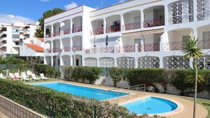 A hotel with multiple balconies, a swimming pool, and a well-maintained garden. - Apartamentos Kings (Loule)