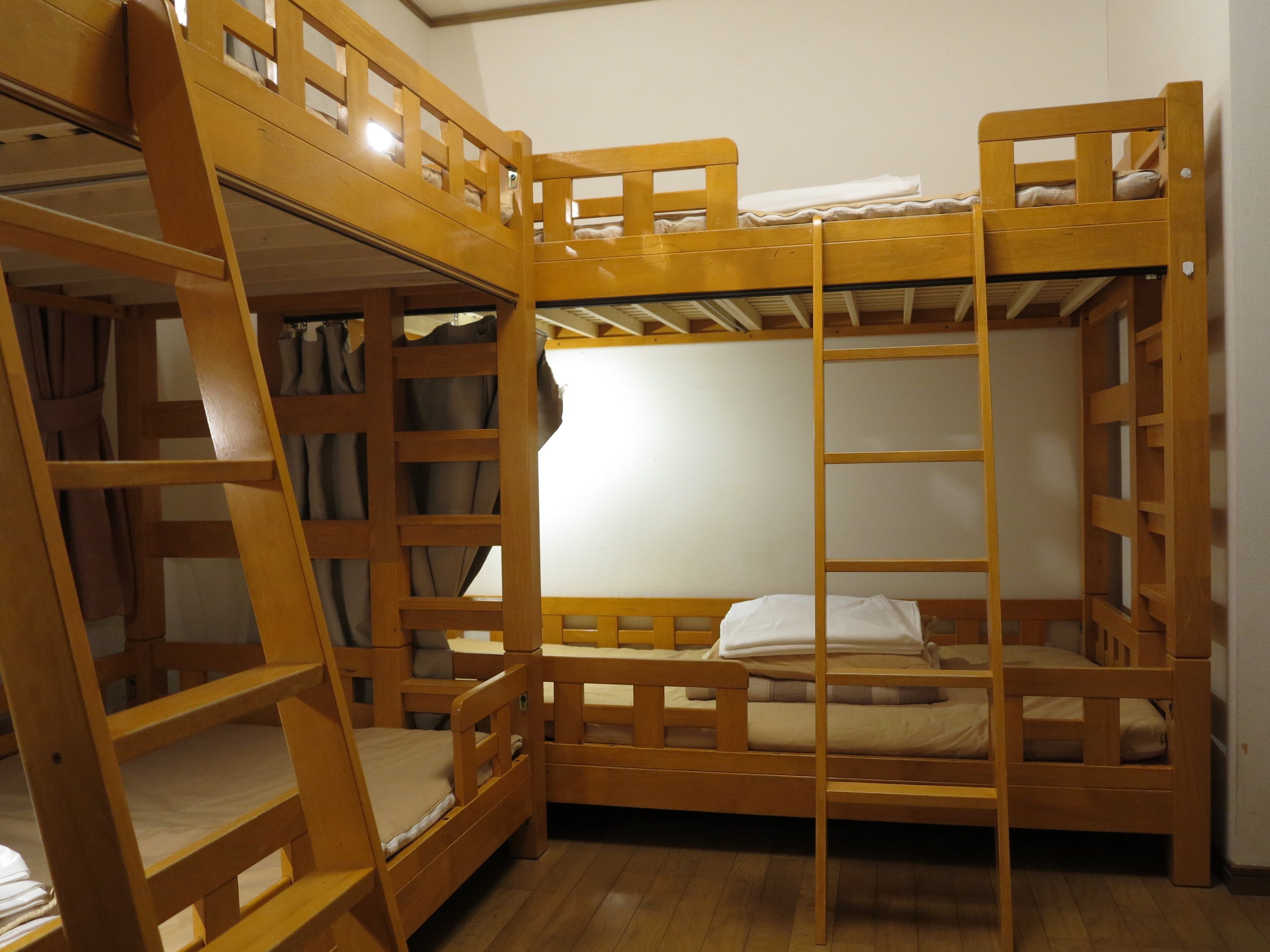A bunk bed room with wooden railings and a ladder.