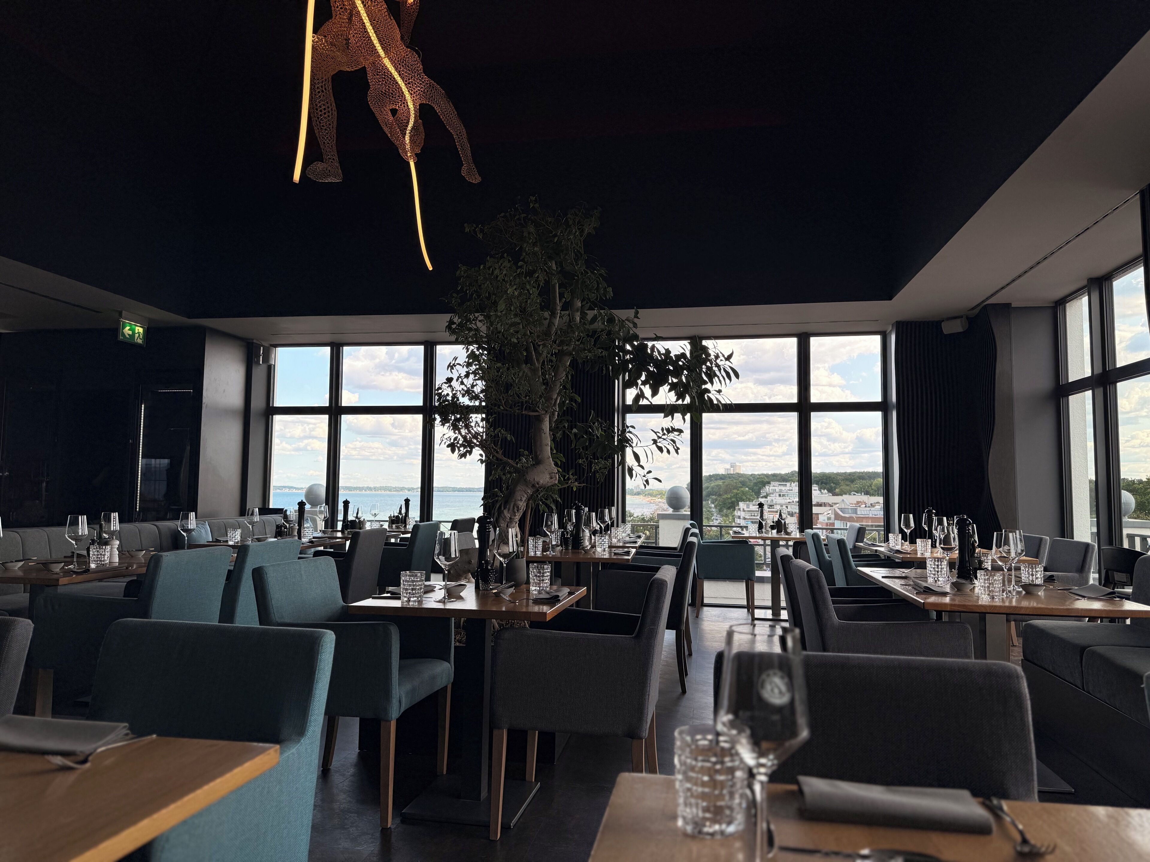 Ein Restaurant mit Meerblick, großen Fenstern und moderner Einrichtung.