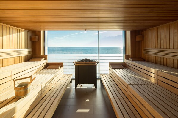 Uma sauna com bancos de madeira e vista para o mar.